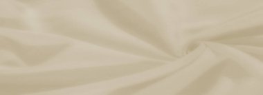 Akan kıvrımları ve yumuşak gölgeleri olan bulanık krem renkli kumaş. Yumuşak dokusu ve narin görünüşü, zarif bir arkaplan için uygun sakin ve minimalist bir görünümü çağrıştırıyor..