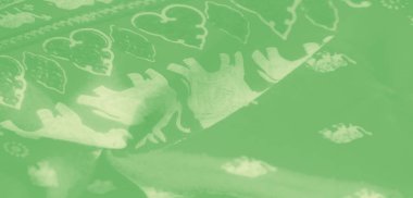 Karmaşık beyaz çiçek desenleriyle süslenmiş bulanık yeşil bir kumaş yumuşak kıvrımlar oluşturmak için nazikçe akıyor. Doku sükunetin özünü yakalar, zarif bir sunum için idealdir..