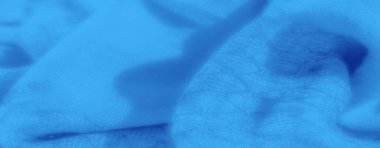 Mavi kumaş bulanıklığı, yumuşak ve akıcı bir dokuyu gösteriyor. Kumaşın kıvrımları ve yumuşak maddesi rahatlatıcı, rüya gibi bir atmosfer yaratarak arka plan tasarımları veya sanatsal projeler için ideal hale getiriyor..