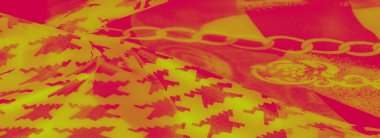 Süslü zincir motifleri ve açısal desenleri olan parlak kırmızı ve sarı tonlardan oluşan karmaşık kumaş bulanıklığı. Yumuşak kıvrımlar lüks tekstile boyut kazandırıyor..