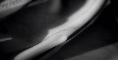 Bulanık, yumuşak siyah kumaşlı, kıvrımlı ve karmaşık gölgeli. Hassas kırışıklıklar ve ışık yansımaları kumaşın lüks ve ipeksi dokusunu geliştirir..