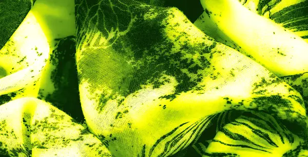 Karmaşık katlanmış yeşil ve siyah kumaş bulanıklığı. Yüksek kontrastlı, dinamik bir kompozisyon için soyut desenler ve parlak çizgiler sergiliyor.