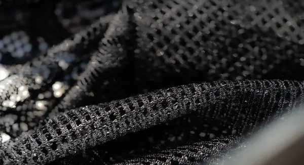 Siyah dantel kumaştan bir bulanıklık parıldayan ışıklar ve ızgara benzeri bir desen. Moda ve iç tasarım için mükemmel ince bir doku yaratıyor..