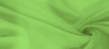 Yumuşak kıvrımlı, pürüzsüz, açık yeşil kumaştan oluşan bulanık bir görüntü. Kumaşın ince dokusu görüntüye derinlik ve akıcı bir estetik katar.