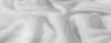 Görüntü. Yumuşak bir buruşuk beyaz kumaş. Karmaşık dokuları ve pürüzsüz akışkan çizgileri var. Hafif gölgelerle vurgulanmış..