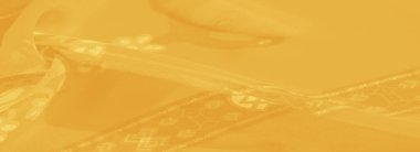 Bulanık sarı kumaş ayrıntılı çiçek desenleri ve parlak bir yüzeye sahip soyut aksanlar, zarif ve geleneksel dekor temaları için idealdir..