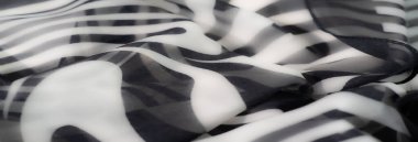 Yakın plan siyah-beyaz kumaş bulanıklığı zarif girdap şekilleri sergiliyor. Tasarım akıcı, organik ve sofistike bir estetik için yumuşak katlanmış..