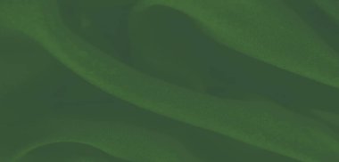 Hassas kırışıklıkları olan, akan yeşil kumaş bulanıklığı. Yumuşaklık ve doku birleşerek bu soyut tasarımda bir ahenk ve lüks hissi yaratır..