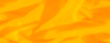 Işıl ışıl kıvrımları ve yumuşak dokuları olan sarı katmanlı bulanık kumaş, canlı renkleri yaratıcı veya dekoratif uygulamalar için soyut bir hisle birleştiriyor..