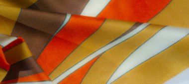 Bulanık - Beyaz aksanlı kahverengi, sarı ve turuncu renkli bir kumaş, kıvrımlı bir desen ile dizilmiş, ipeksi ve ince, akıcı dokular, zarafet katıyor.