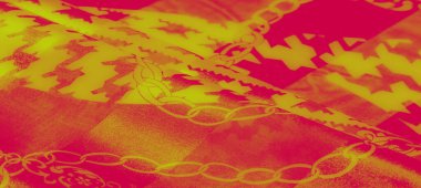 Karmaşık zincir desenleri ve açısal tasarımları olan koyu kırmızı ve sarı kumaştan oluşan bir bulanıklık. Parlak kıvrımlar lüks ve soyut dokuları vurgular..