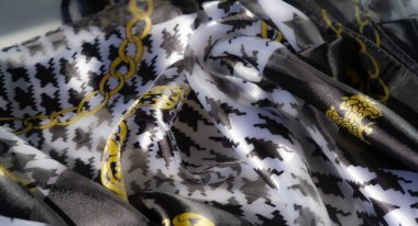 Bulanık, parlak turuncu kumaş, ince beyaz çizgili ve sarı çiçek desenli. Yumuşak kıvrımlar, tekstil tasarımları için mükemmel bir ışık ve doku etkileşimi yaratır..