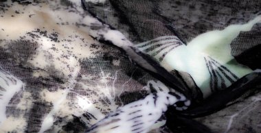 Siyah beyaz kumaşın bulanık sanatsal görüntüsü. Yeşil aksanlar ve karmaşık desenler. Yumuşak kıvrımlar ve ince dokularla dizayn edilmiş.