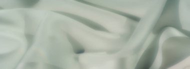 Yumuşak, pastel yeşil kumaştan bulanık kıvrımlar, kıvrımlar ve akışkan katmanlar halinde sanatsal olarak düzenlenmiş, organik bir doku ve sakinleştirici bir öz yayıyor, yaratıcı projeler ve görsel tasarımlar için ideal..