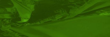 Parlak çiçekli ve soyut detaylara sahip bulanık yeşil kumaş, pürüzsüz kıvrımlar ve lüks ve sanatsal görünüş için kusursuz bir doku..