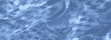 Bulanık noktalar, geometrik desenler ve zincir benzeri motiflerle süslenmiş mavi kumaşın karmaşık kıvrımları, hassas ve modern bir estetik yaratıyor.