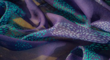 Mor bir taban üzerinde karmaşık deniz mavisi ve turkuaz nokta desenli bulanık kumaş. Yumuşak, akışkan kıvrımlar, hafif oyun ve yumuşak dokuyla geliştirilmiş bir derinlik hissi yaratır..