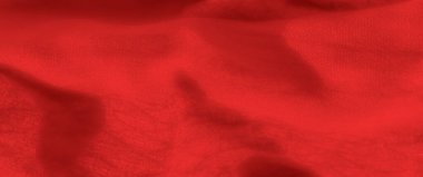Yumuşak kıvrımları ve yumuşak gölgeleri olan canlı kırmızı bir kumaşın bulanıklığı. Kumaş akışı ve zengin dokusu onu sıcak ve davetkar bir arka plan için ideal kılıyor.