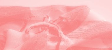 Pembe kumaşın parıldayan iplikleri ve doğal kıvrımlarıyla detaylı bir görünümü, ışık ve dokunun etkileşimini ortaya koyuyor, tekstil ilhamı veya sanatsal kullanım için ideal..