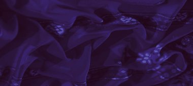 Görüntü, geometrik bir tasarım üzerinde karmaşık örgülü desenli mor kumaştan çarpıcı bir kare modern zarafet için dokulu ve parlak bir estetik sunuyor..