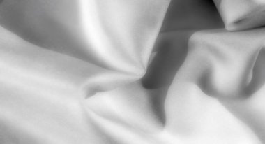 Organik katlar ve yumuşak gölgelerden oluşan bulanık gri tonlu kumaş, pürüzsüz, ipeksi dokusunu vurguluyor, minimalist ve soyut tasarım projeleri için mükemmel..