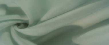 Bulanık pastel, nane yeşili kumaşlar yumuşak ve akışkan bir kompozisyonda sıralanmış, dingin bir estetik için ince dokular ve açık gölgeler vurgulanıyor..