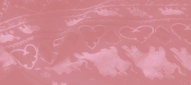 Bulanık pembe kumaş. Karmaşık fil desenleri ve çiçek motifleri var. Yumuşak ve lüks bir tekstil etkisi için nazikçe katlanmış..