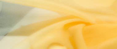 Yumuşak kıvrımları ve ince kıvrımları olan parlak sarı kumaş bulanıklığı pürüzsüz, davetkar bir doku sergiliyor. Sıcak, aydınlık yüzey, rahatlatıcı bir atmosferi olan, minimalist, sakin bir zemin oluşturur.