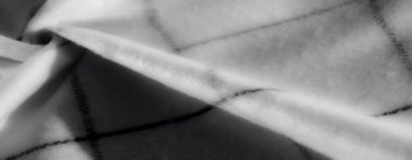 Bulanık, gri tonlarda pürüzsüz kumaş zarif kıvrımlar ve siyah geometrik çizgiler. Işıklar ve gölgeler yumuşak maddenin dokusunu güçlendirir.