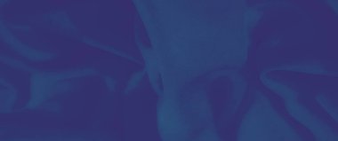 Yumuşak katları ve dokuları olan koyu mavi bir kumaşın bulanıklığı rahatlatıcı ve dingin bir estetik yaratıyor. Görüntü ince dokumaları ve nazik kırışıklıkları vurgular.