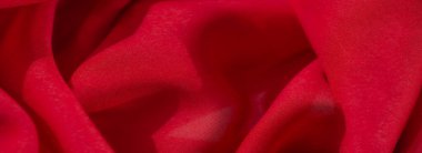 Yumuşak ve kadife görünümlü canlı kırmızı bir tekstil bulanıklığı, yumuşak kıvrımları derinlik ve yaratıcı ve tekstil odaklı projeler için zengin bir görsel cazibe yaratıyor..