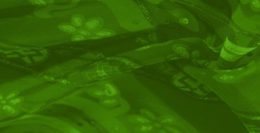 Bulanık yeşil tekstil soyut çiçek desenleri ve ışıltılı renklerle süslenmiş zarif dekorlar ve moda eserleri için zarif ve canlı bir görünüm yaratıyor..