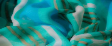 Altın aksanlı bulanık mavi ve yeşil kumaş desenli ve göz alıcı bir zarafet ve büyüleyici bir sanatsal tasarım yaratır..