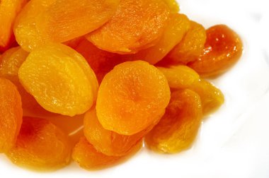 Kurumuş kayısılar parlak dokuları ve canlı renkleriyle bir araya toplanmış. Bu canlı yakın plan çekimde sağlıklı atıştırmalık cazibelerini sergiliyorlar..