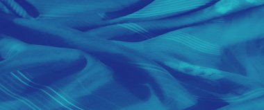 Canlı mavi kumaş üzerinde bulanık bir etki. Yumuşak kıvrımlar, ince çiçekli desenler ve çizgili detaylar. Sakin ve narin bir doku yaratıyor..