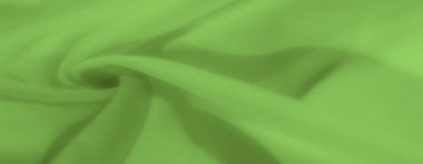 Pürüzsüz, yumuşak dalgalarla kıvrılmış canlı yeşil kumaş bulanıklığı. Kumaşlar katmanlı dokular ve sakin yeşil gölgeler yumuşak ve organik bir etki yaratıyor.