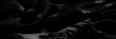 Görüntü - Cesur beyaz fil siluetleri ve karmaşık çiçek desenleri içeren dinamik gri ölçekli bir kumaş..