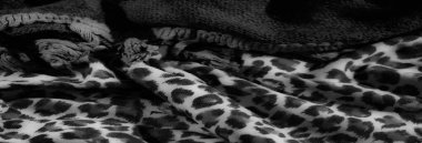 Katmanlı leopar desenli kumaşların çarpıcı tek renkli görüntüsü örgülü ip detaylarıyla zıt, ince zarafetle kalın dokuları dengeliyor..