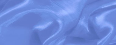 Bulanık, açık mavi saten kumaşın yumuşak parıltılı ve lüks dokusunu vurgular, parlak katlar ve akışkan bir tasarımda pürüzsüz yansıtıcı gölgeler.