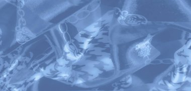 Açık mavi kumaşın bulanık kıvrımları, karmaşık zincir ve geometrik motifler, rüya gibi bir doku ve soyut ışık ve gölge akışı yaratır..