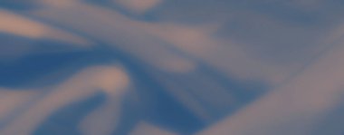 Artistik ve zarif bir sunum için yumuşak ışıkla aydınlatılan, yumuşak kıvrımlı, yumuşak, mavi kumaştan oluşan bulanık bir görüntü..