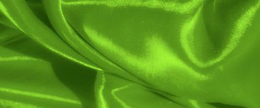 Yumuşak yeşil kumaşın bulanık kıvrımları zarafetle dalgalanır, akış hissi yayar ve organik hareket karmaşık dokusunu vurgular ve aydınlatır..