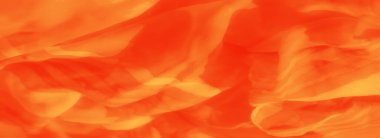 Zarif kıvrımlı parlak turuncu saten kumaştan bir bulanıklık ve parlak bir parıltı sanatsal ve yaratıcı kullanım için zarif ve dinamik bir kompozisyon oluşturuyor..