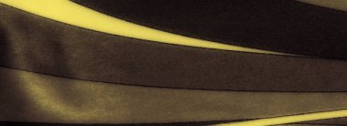 Görüntü. Yumuşak ve akışkan sarı ve siyah kumaş. Değişken desenleri var. Gölge ve ışığın soyut bir karışımını yakalıyorlar. Kavisli, çapraz çizgiler zarafeti çağrıştıran pürüzsüz bir doku oluşturuyor.