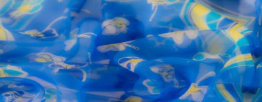 Bulanık mavi kumaş, sarı ve deniz mavisi desenleriyle süslenmiş. Yumuşak kıvrımlar ve şeffaf bir kaplama hafif, havadar ve tuhaf bir estetik yaratıyor tekstil için mükemmel..