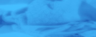 Narin kıvrımlı mavi kumaş ve pürüzsüz, yumuşak bir yüzey. İç dekorasyon ve soyut tekstil projeleri için uygun sakin ve rahatlatıcı bir estetik.