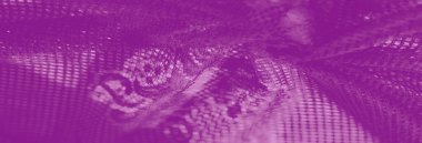 Karmaşık bir geometrik tasarımı olan mor dantel kumaş bulanıklığı ince dokusunu ve yayılmış ışık altında narin zanaatını sergiliyor. Sanatsal tekstil için mükemmel..