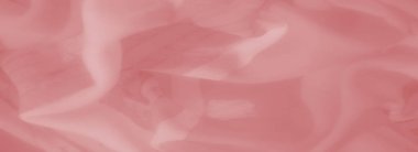 Yumuşak kıvrımlı pembe saten kumaştan bulanık bir yakın çekim, parlak ve pürüzsüz bir doku sergiliyor. Işık, maddenin üzerinde hafifçe dans eder, ruhani ve zarif bir etki yaratır..