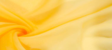 Yumuşak, sarı bir kumaşın bulanık kıvrımları pürüzsüz ve nazik bir görünüm yaratıyor. Bu canlı sarı tekstil sıcaklık ve zarafet sunuyor, arka plan kullanımı için mükemmel..