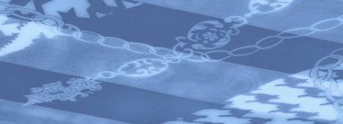 Simetrik geometrik ve zincir desenleriyle süslenmiş, karmaşık ayrıntıları ve modern sanatsal dokunuşu yansıtan bulanık mavi kumaş kıvrımları..